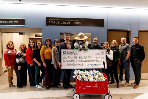 A large check with a group of hospital representatives